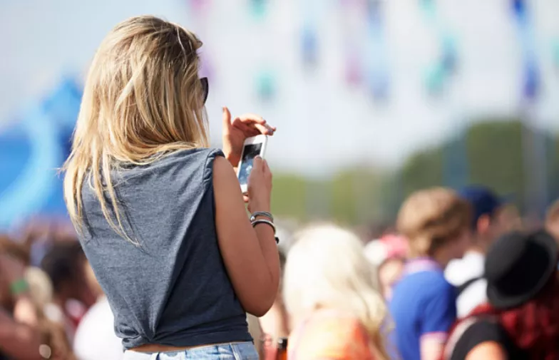 vrouw met telefoon op festival